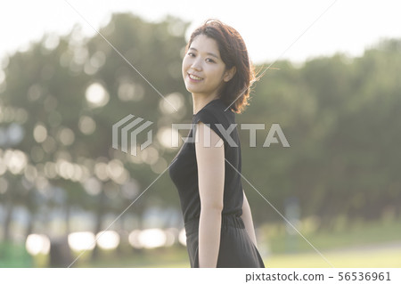 Young woman walking in the park by the sea Young woman walking in the park by the sea 56536961