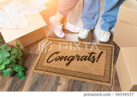Man and Woman Unpacking Near Welcome Mat Man and Woman Unpacking Near Welcome Mat 56548557