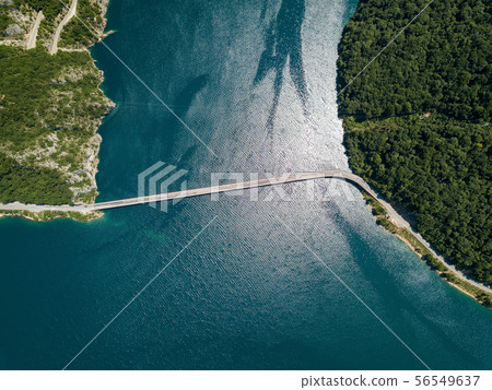 Aerial footage a car driving over a bridge on Piva Lake Aerial footage a car driving over a bridge on Piva Lake 56549637