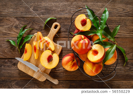 Ripe peaches with leaves in basket 56550229