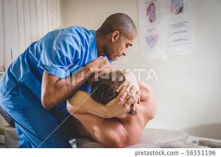Chiropractor doing adjustment on female patient Chiropractor doing adjustment on female patient 56551196