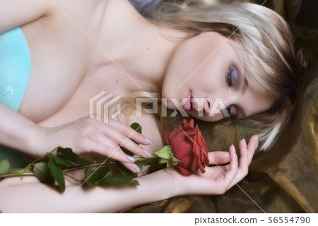 closed eyes Beautiful woman with red rose laying. closed eyes Beautiful woman with red rose laying. 56554790