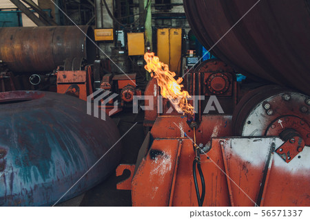 Huge metal tunnel made of rounded steel pipes in the factory hall. Huge metal tunnel made of rounded steel pipes in the factory hall. 56571337