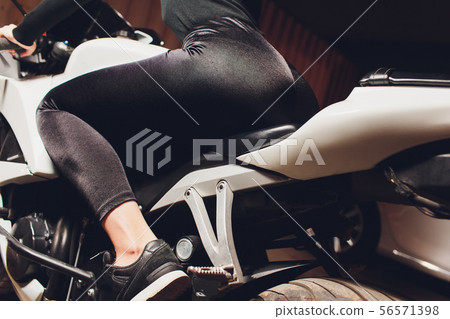 Young girl in leather jacket and leggings sitting on motorcycle, seductive slim biker girl with Young girl in leather jacket and leggings sitting on motorcycle, seductive slim biker girl with 56571398