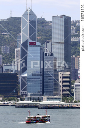 A colorfully painted sightseeing boat star ferry in front of a skyscraper in Hong Kong. It is not used for normal routes. 56571591