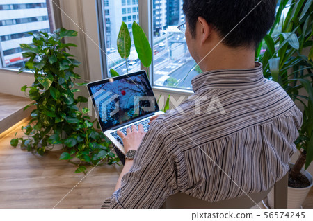Man operating laptop on lap Man operating laptop on lap 56574245