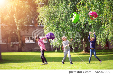 Children with rucksacks standing in the park near school 56582009