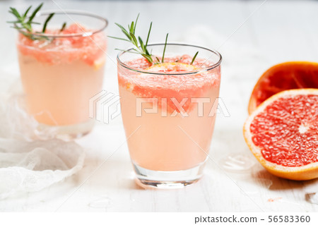 Glass of grapefruit drink with ice and rosemary Glass of grapefruit drink with ice and rosemary 56583360