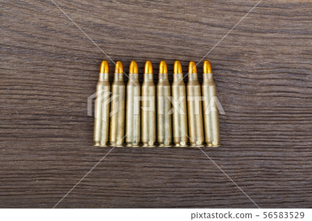 Rifle bullets on wood table close up. Rifle bullets on wood table close up. 56583529