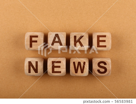 Wooden cubes with FAKE NEWS words over brown 56583981