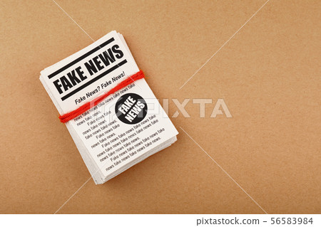Stack of FAKE NEWS newspapers over brown paper 56583984