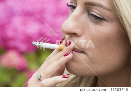 Young woman smoking a cigarette 56585746