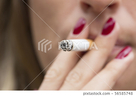 Young woman smoking a cigarette 56585748