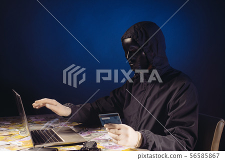 Anonymous hacker in mask programmer uses a laptop Anonymous hacker in mask programmer uses a laptop 56585867
