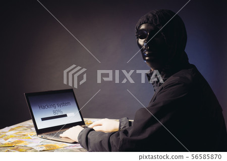Anonymous hacker programmer uses a laptop to hack 56585870