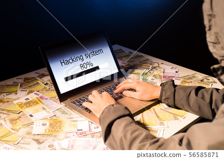 Anonymous hacker programmer uses a laptop to hack 56585871