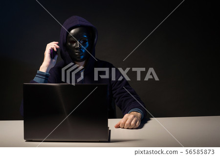 Anonymous hacker in mask programmer uses a laptop Anonymous hacker in mask programmer uses a laptop 56585873
