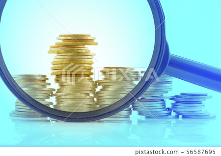Magnifying glass with pile of coins 56587695