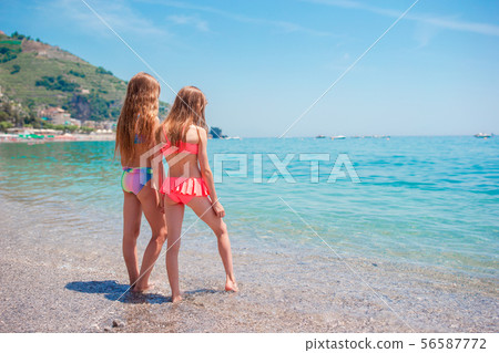 Two little happy girls have a lot of fun at tropical beach playing together Two little happy girls have a lot of fun at tropical beach playing together 56587772