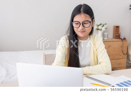 Asian female freelancer working on laptop computer 56590198