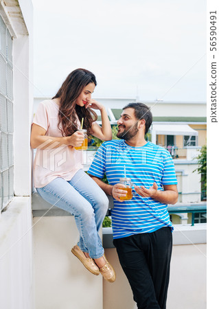Indian couple on apartment balcony Indian couple on apartment balcony 56590491