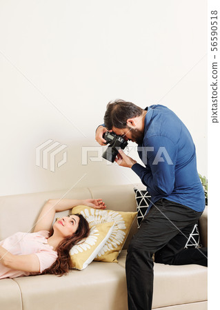 Man photographing his girlfriend 56590518