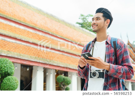 Handsome asian man tourist walking and looking Handsome asian man tourist walking and looking 56598253