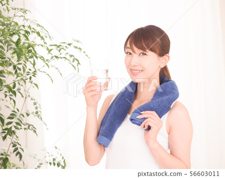 Woman exercising and drinking water 56603011