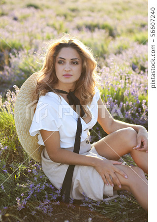 Beautiful woman in straw hat in violet lavender Beautiful woman in straw hat in violet lavender 56607240