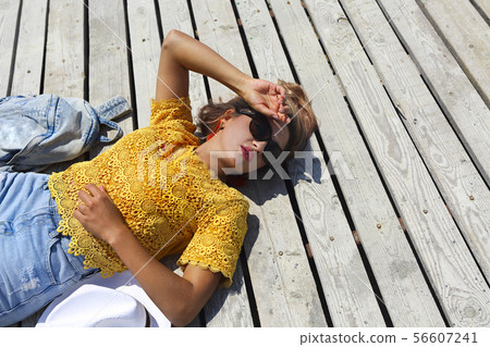 Young happy blond woman at wooden background Young happy blond woman at wooden background 56607241