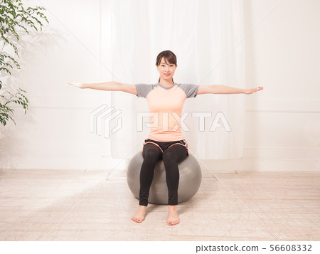 A woman riding a balance ball 56608332