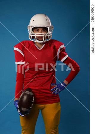 Photo of young american woman football player in white helmet, sportswear with ball in her hand Photo of young american woman football player in white helmet, sportswear with ball in her hand 56609009