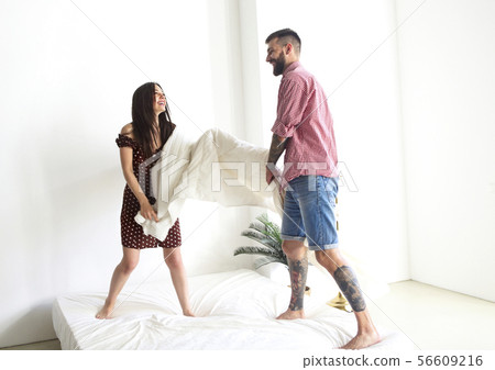 Young tattooed stylish couple hugging in bedroom Young tattooed stylish couple hugging in bedroom 56609216