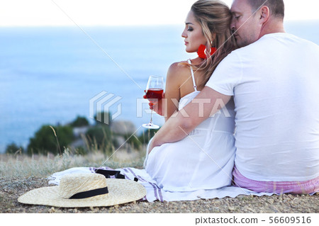 Lovely coupleby the sea drinking rose wine 56609516