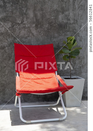 Red beach chair on outdoor terrace in contrast of Red beach chair on outdoor terrace in contrast of 56612841