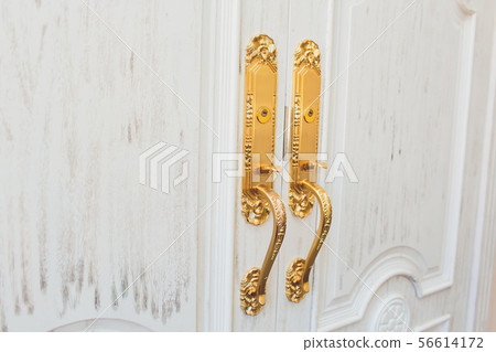 Close up of classic golden door handle on white door. 56614172