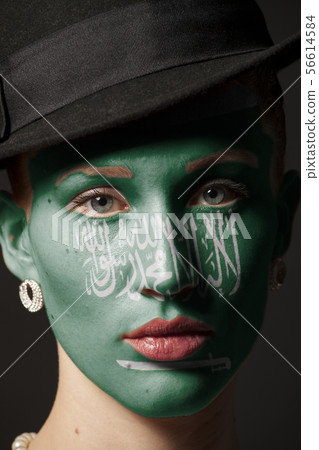Woman face with painted Flag of kingdom of Saudi Woman face with painted Flag of kingdom of Saudi 56614584