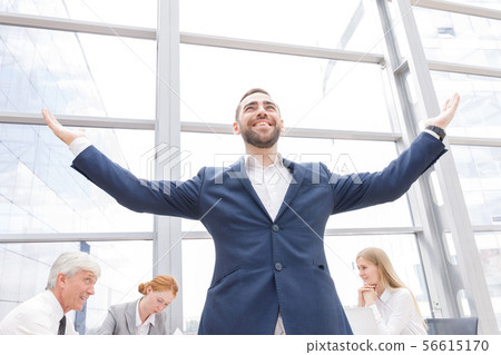 Young businessman with raised arms Young businessman with raised arms 56615170