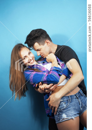 happy couple together posing cheerful on blue background wearing glasses, guy and girl students happy couple together posing cheerful on blue background wearing glasses, guy and girl students 56616088