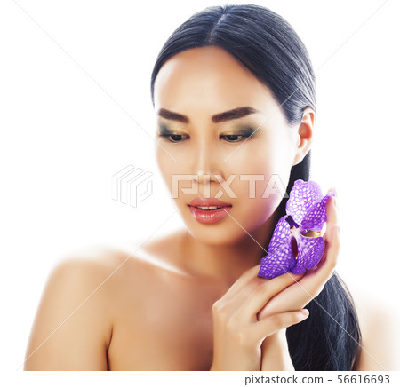 young pretty asian woman with flower purple orchid close up isolated spa, womans day concept 56616693