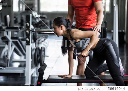trainer coach dumbbell exercise to woman 56616944