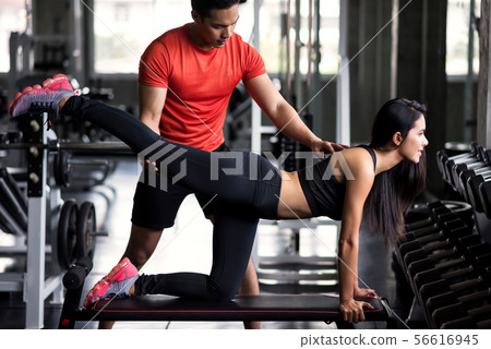 Woman stretch back and leg with trainer 56616945