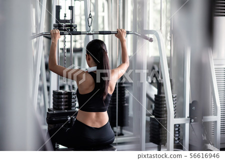 woman exercise with lat pulldown machine in gym woman exercise with lat pulldown machine in gym 56616946