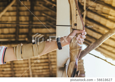 Tourists try to use a bow and arrow and shoot Tourists try to use a bow and arrow and shoot 56618627