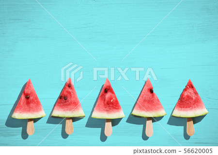 Watermelon slice popsicles on a blue color background Watermelon slice popsicles on a blue color background 56620005