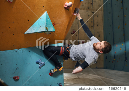 Physically handicapped sportsman starts climbing training in bouldering center Physically handicapped sportsman starts climbing training in bouldering center 56620246