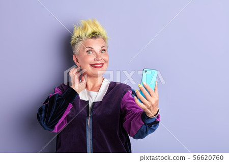 happy sporty senior woman taking selfie with mobile phone indoors 56620760