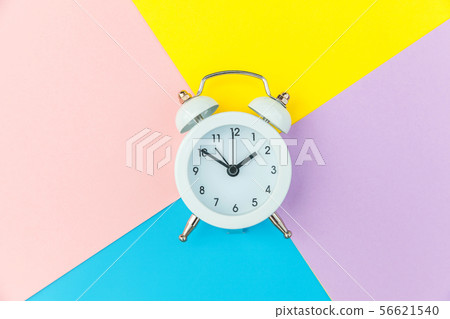Vintage alarm clock isolated on blue yellow pink pastel colorful trendy geometric background 56621540