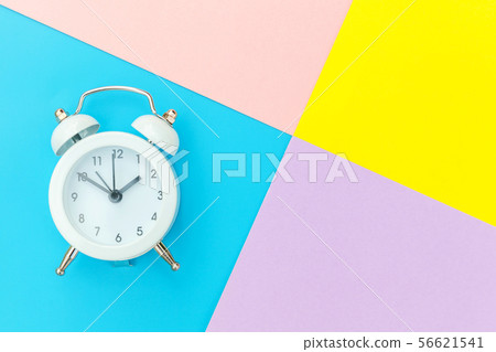 Vintage alarm clock isolated on blue yellow pink pastel colorful trendy geometric background 56621541