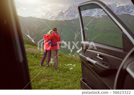 Happy couple hugs on beautiful nature and mountains out of car  56623322